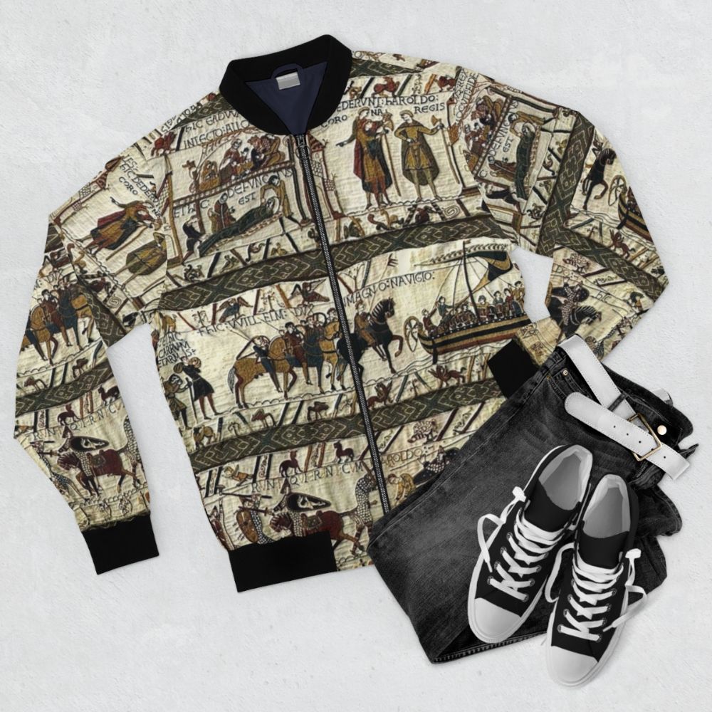 Bayeux Tapestry inspired medieval-style bomber jacket with Viking boats, horses, and battle scenes - Flat lay