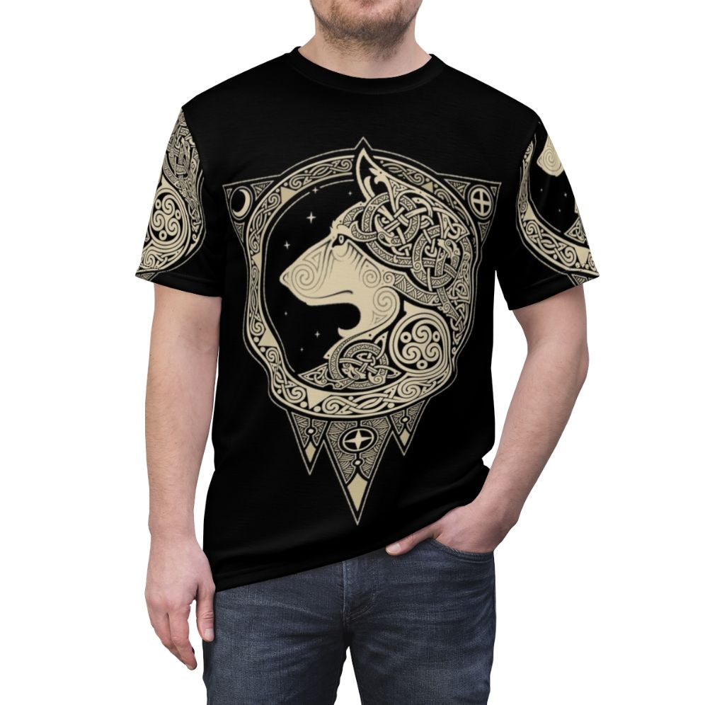 Photograph of a Norse-inspired t-shirt with a detailed wolf graphic, set against a background of celestial symbols and organic patterns. - men front