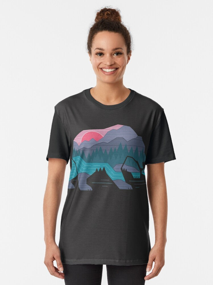 A minimalist graphic t-shirt design featuring a bear in a wilderness landscape with mountains, river, and forest. - Women