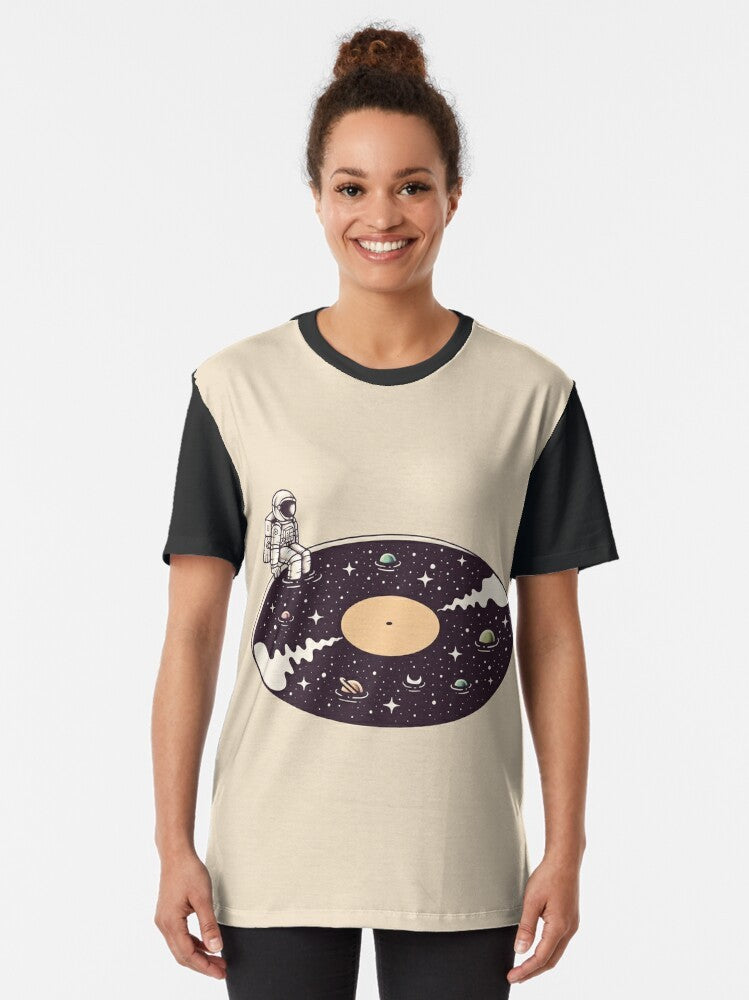 Cosmic Sound Graphic T-Shirt featuring a surreal design of an astronaut, stars, planets, and vinyl record - Women