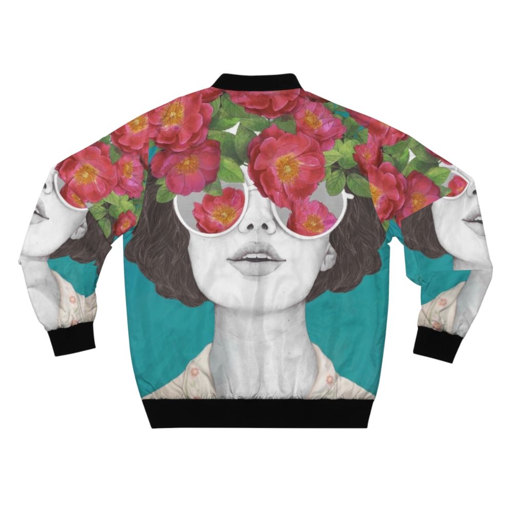 A rose-tinted watercolor bomber jacket with a surreal, abstract floral design featuring a woman's face and glasses. - Back