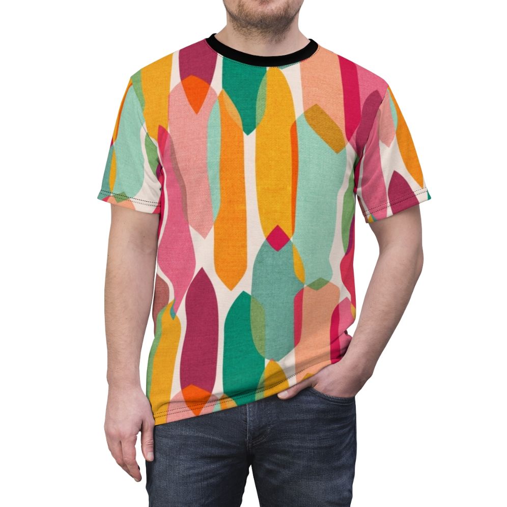 Model wearing a t-shirt featuring a vibrant mid century modern inspired abstract droplet pattern in a colorful kaleidoscope design - men front