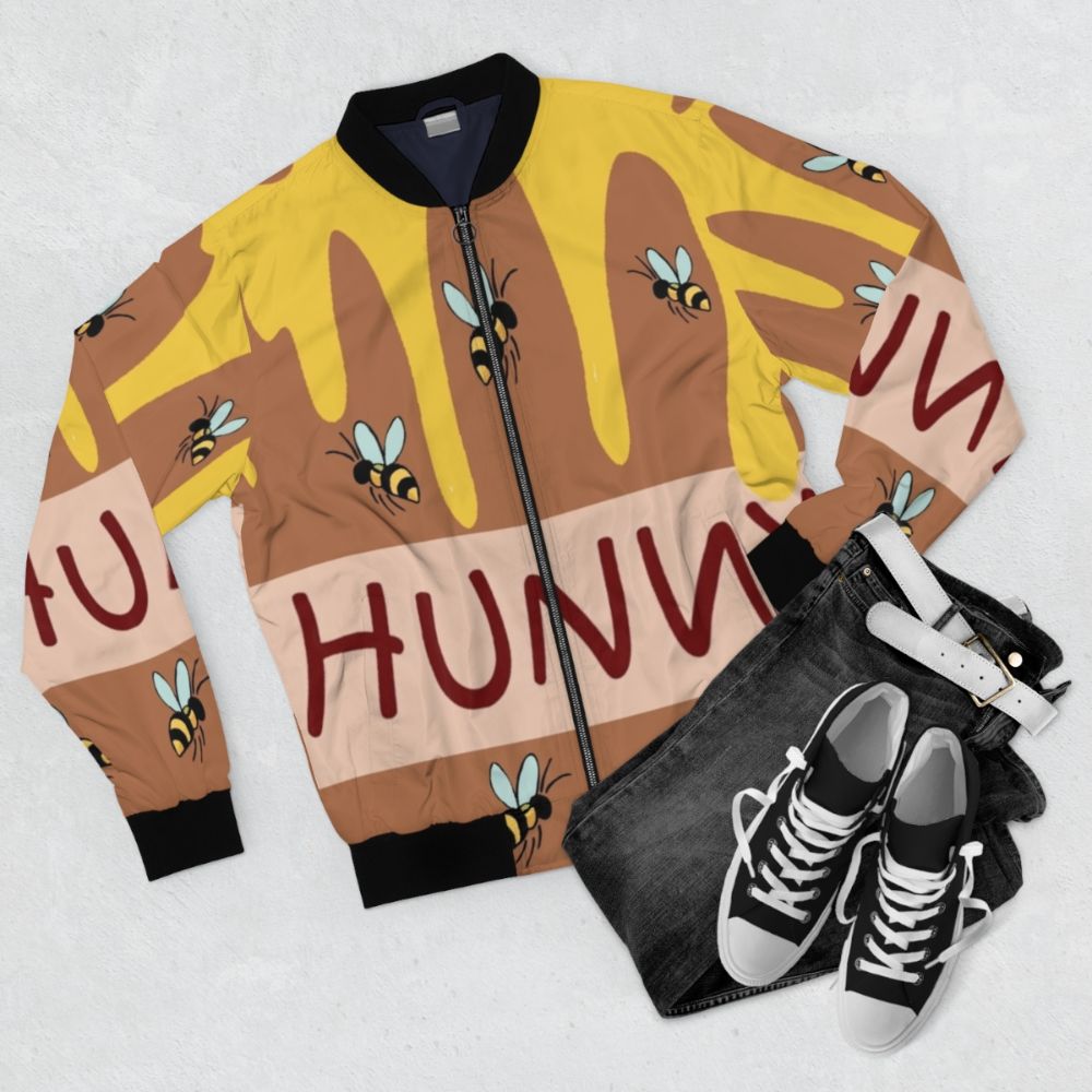 The Honey Pot Bomber Jacket, featuring a cute cartoon bear design and honey pot - Flat lay