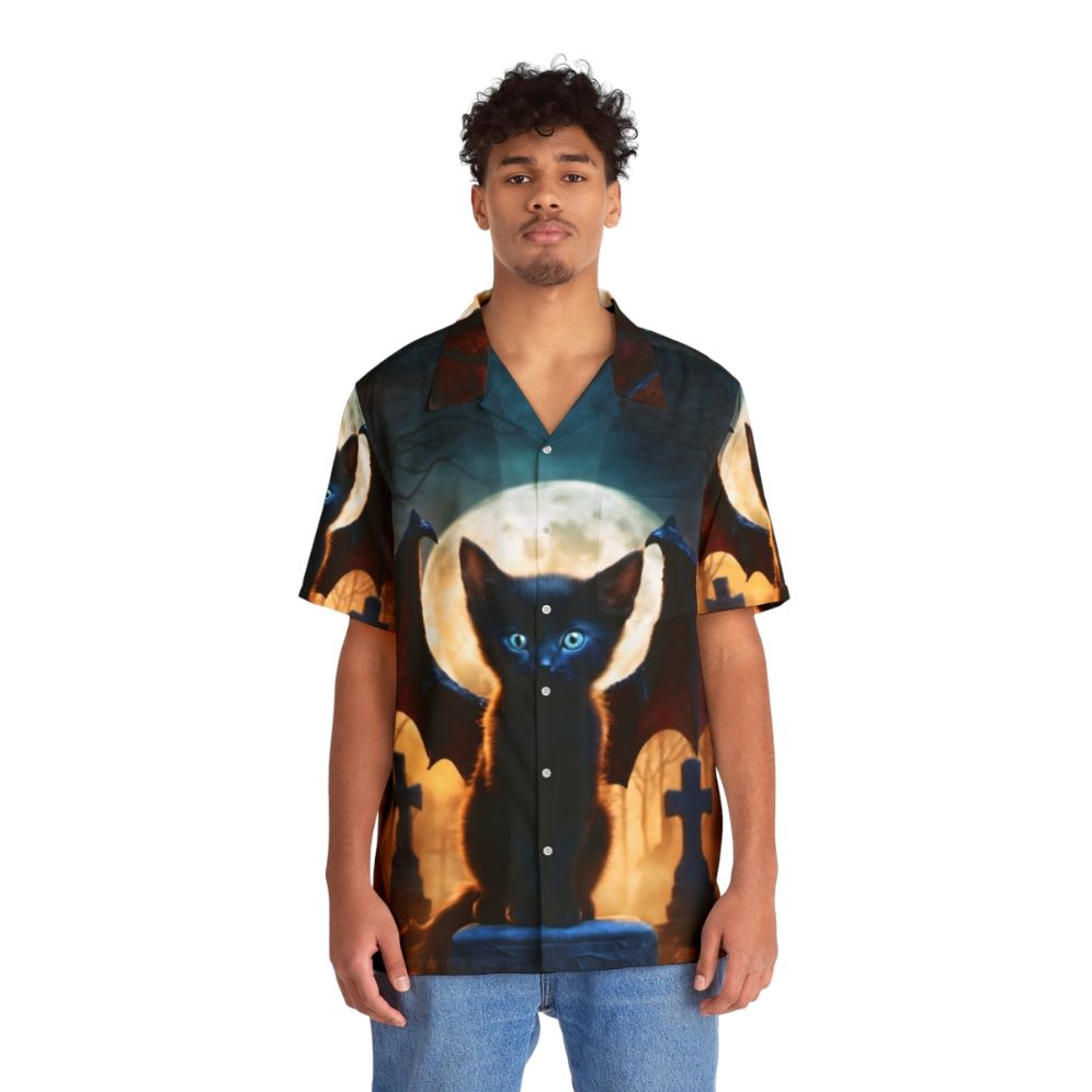 A black dragon kitten sitting in a graveyard on a colorful, digital fantasy Hawaiian shirt - People Front