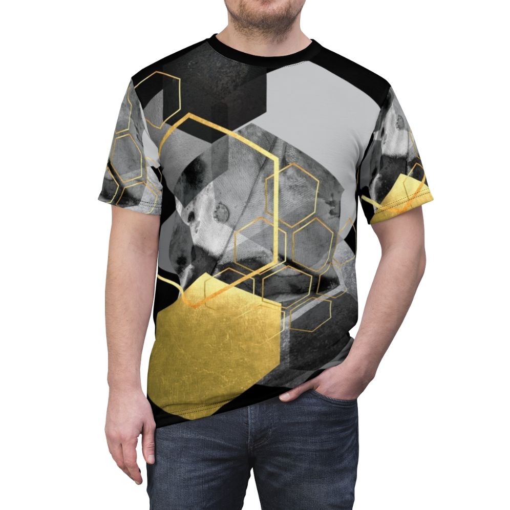 Closeup of a modern, minimalist t-shirt featuring a geometric hexagon collage design in black, white, and gold tones. - men front