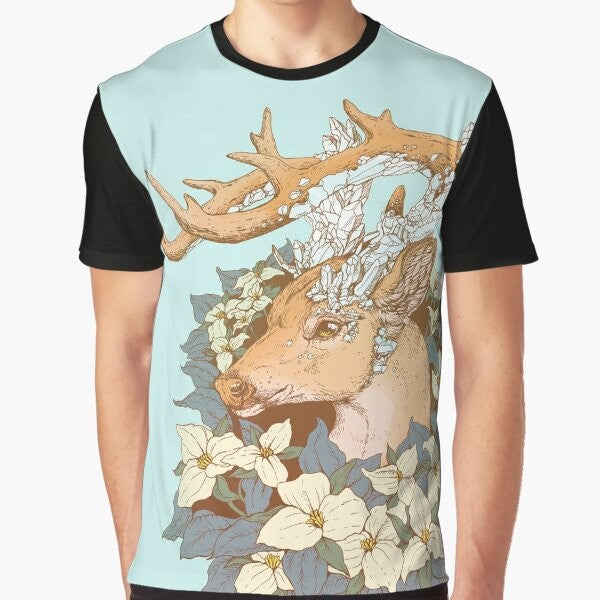 A graphic t-shirt featuring a non-typical blue quartz buck design with antlers and trillium flowers in a nature-inspired illustration.