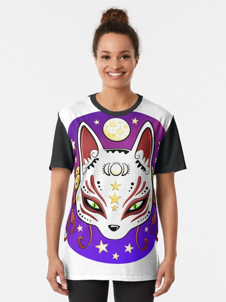 Cute and whimsical graphic t-shirt featuring a kitsune (Japanese fox) mask design with stars, moon, and magical elements. - Women