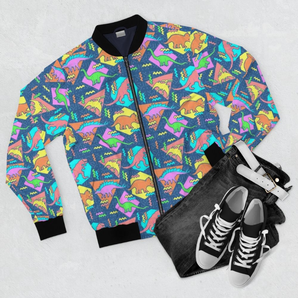 Nineties-inspired bomber jacket with a vibrant dinosaur and geometric pattern design. - Flat lay