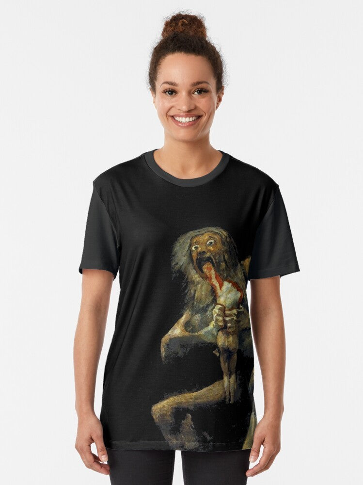 A graphic t-shirt featuring the renowned painting "Saturn Devouring His Son" by the Spanish artist Francisco Goya. - Women