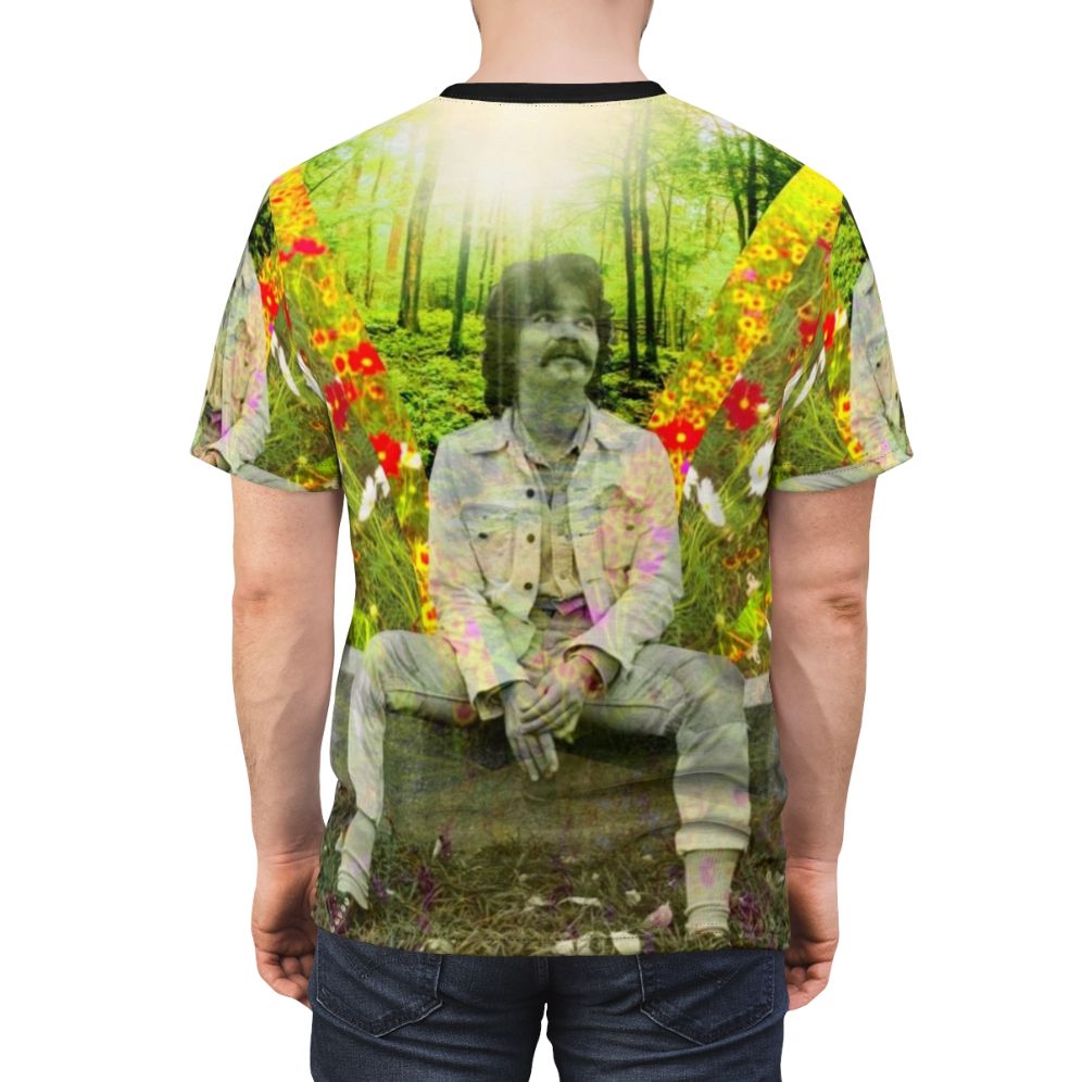 A black and white t-shirt design featuring colorful flowers and text honoring the late folk music legend John Prine. - men back