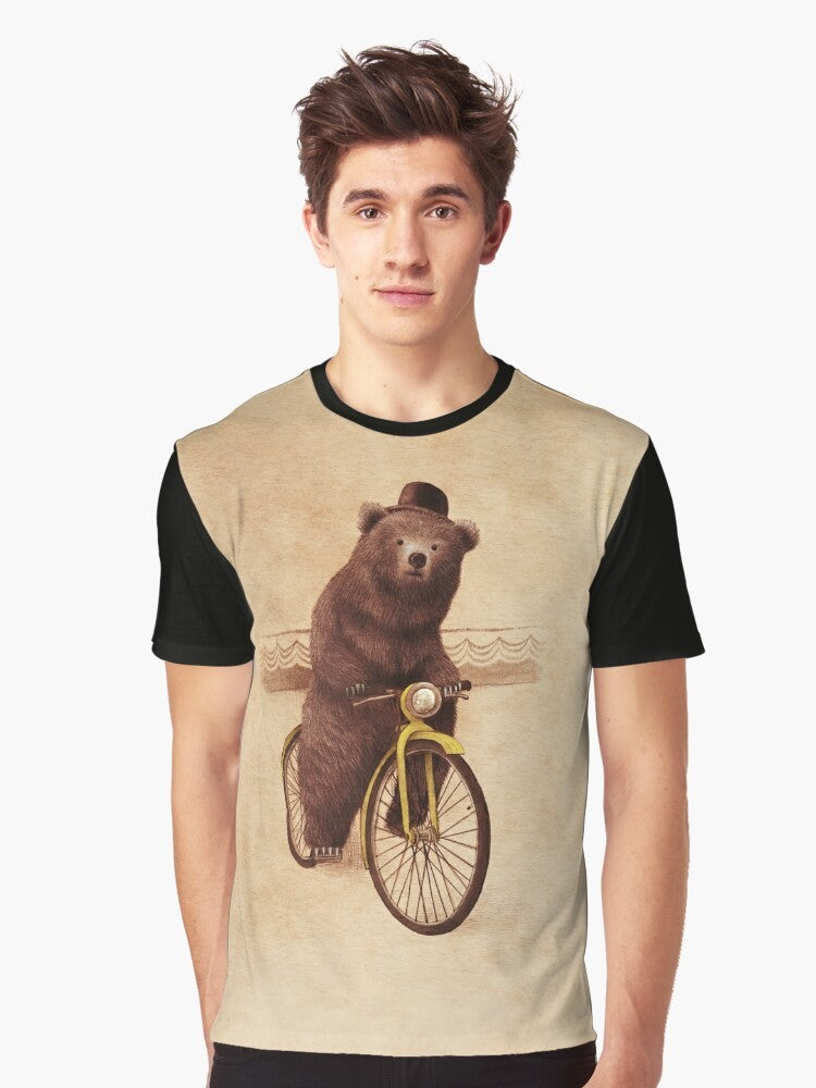 A whimsical graphic t-shirt featuring a vintage-style illustration of a bear riding a bicycle, wearing a bowler hat against a sepia-toned background. - Men