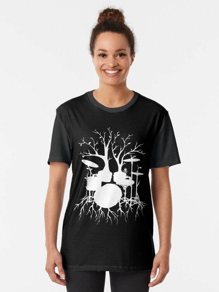 Surreal graphic t-shirt design featuring a silhouetted drum tree, symbolizing the connection between music and the natural world. - Women