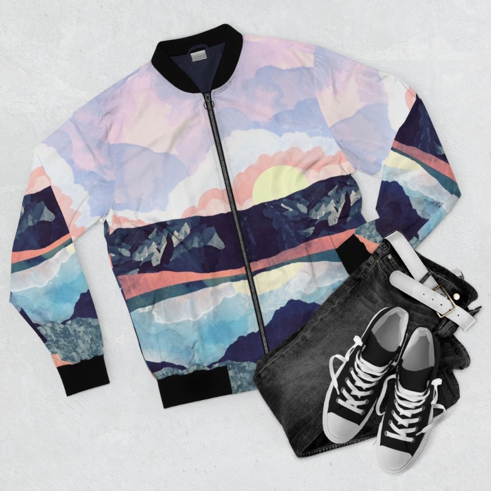 A bomber jacket with a serene lake reflection landscape design - Flat lay