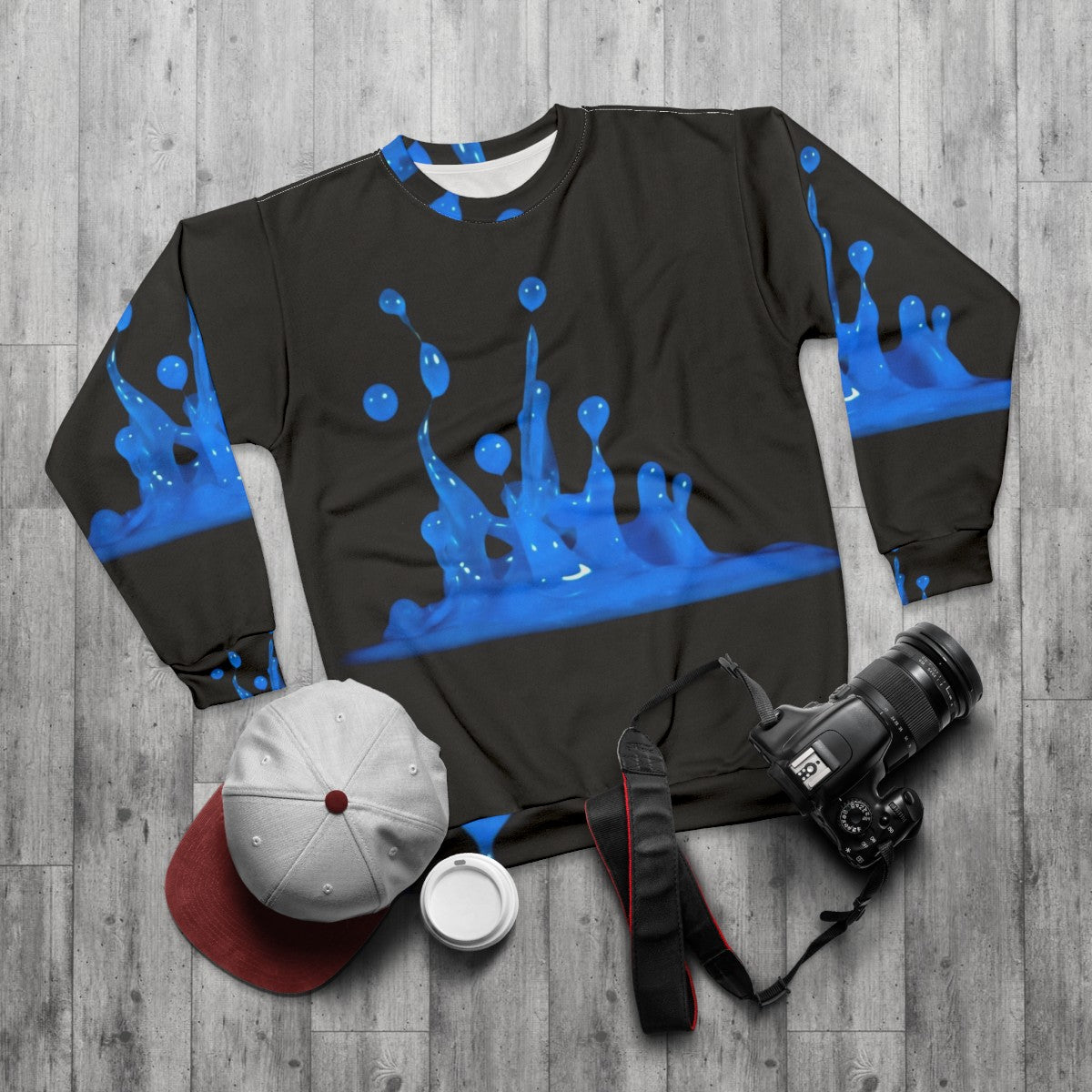 Blue sweatshirt with abstract water splash design - flat lay