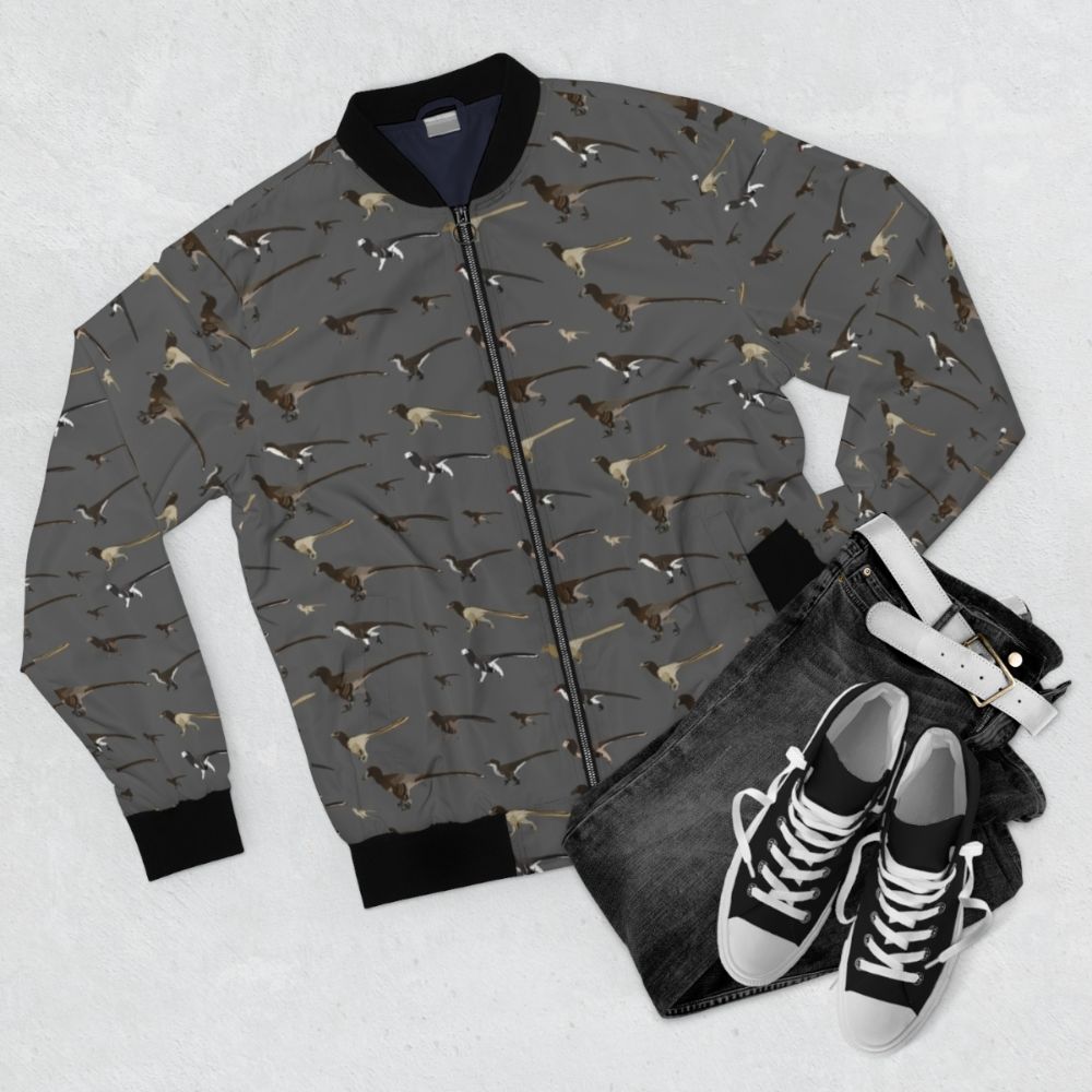 Dromaeosaur pattern bomber jacket with a velociraptor palaeoart design - Flat lay