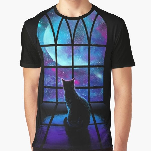 A graphic t-shirt featuring a cute cat in a space-themed design with planets, stars, and the moon.