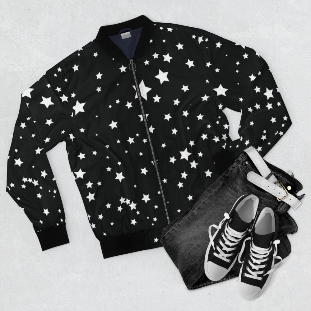 A black and white bomber jacket with a scattered star cluster design, creating a cosmic and spacious aesthetic. - Flat lay