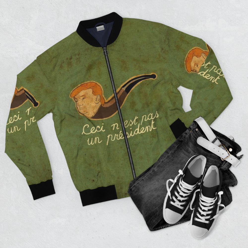 Surreal bomber jacket with "This is Not a President" design, inspired by Rene Magritte's surrealist artwork - Flat lay