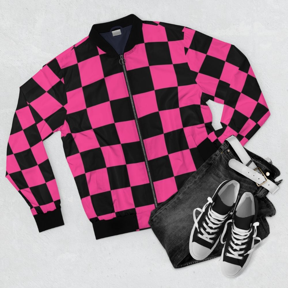 A stylish black and pink checkerboard pattern bomber jacket with a geometric design. - Flat lay