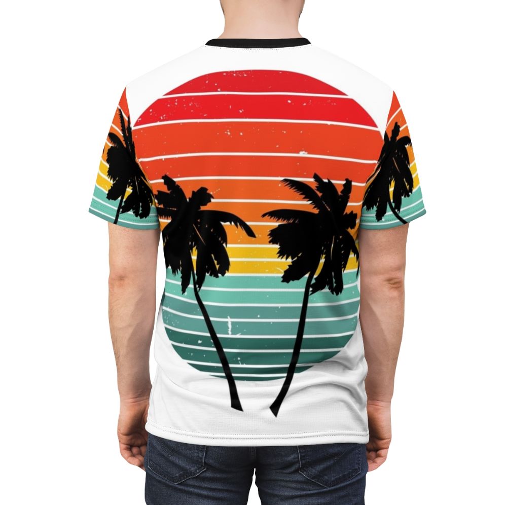 Person wearing a black t-shirt with a vivid tropical palm tree and sunrise silhouette design - men back