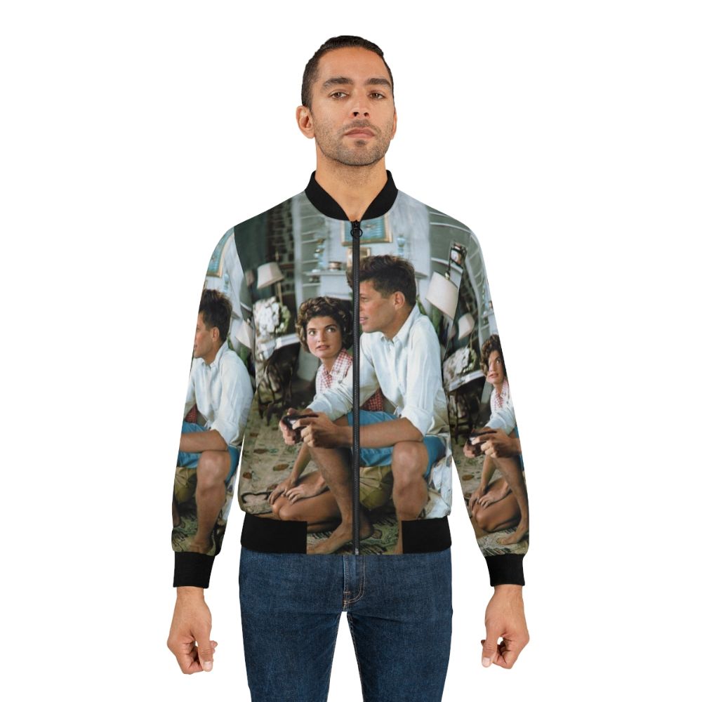 A bomber jacket featuring a graphic of John F. Kennedy playing a PlayStation 4 controller with the "Press F" text. - Lifestyle