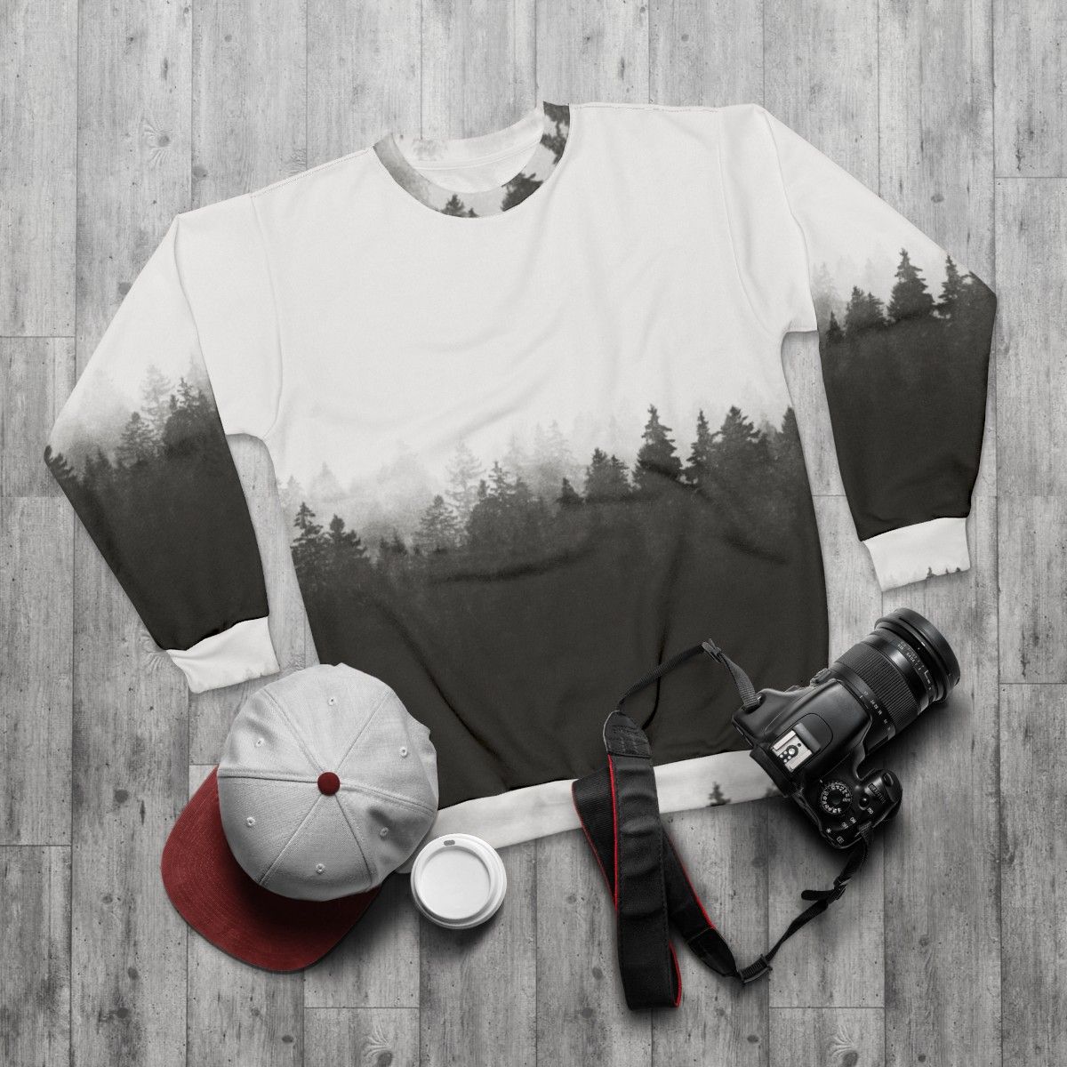 A person hiking in a foggy, forested landscape wearing a nature-inspired sweatshirt - flat lay