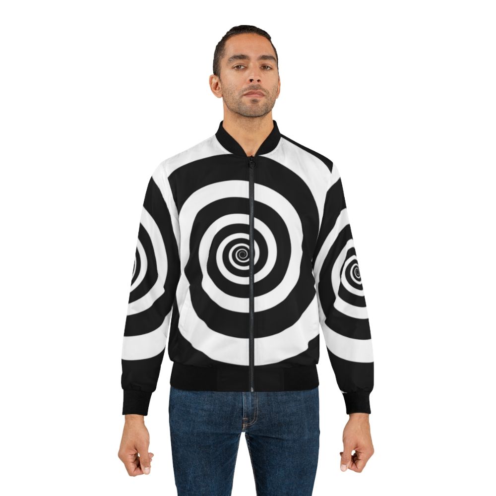 A black and white bomber jacket with a hypnotic spiral visual illusion pattern, perfect for a retro or psychedelic look. - Lifestyle