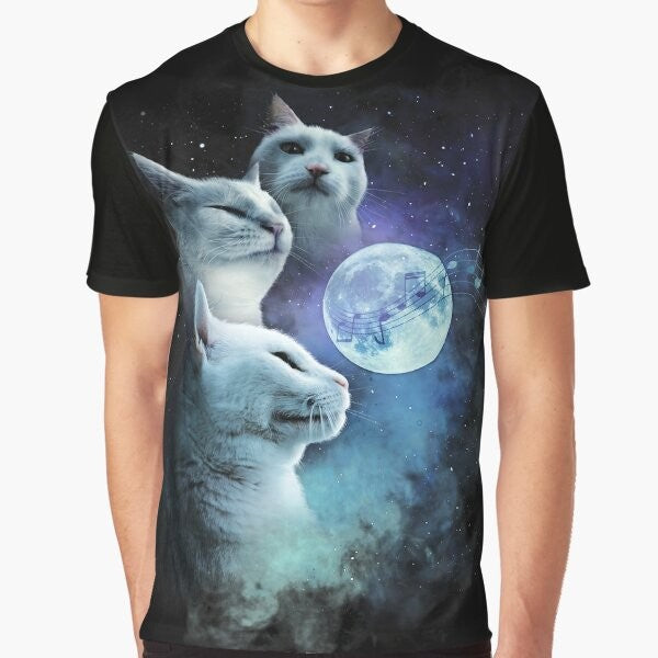 A graphic t-shirt featuring a cat vibing to music in a cosmic, galaxy-themed design with three cats and a moon.