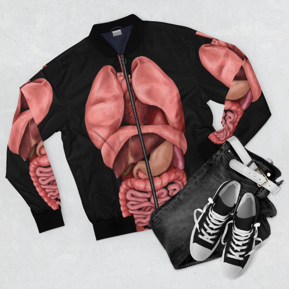 Bomber jacket featuring a detailed watercolor illustration of the human internal organs and anatomy - Flat lay