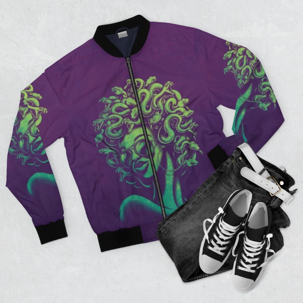 A funky, retro-inspired bomber jacket featuring a Medusa graphic design with an afro hairstyle and sunglasses. - Flat lay