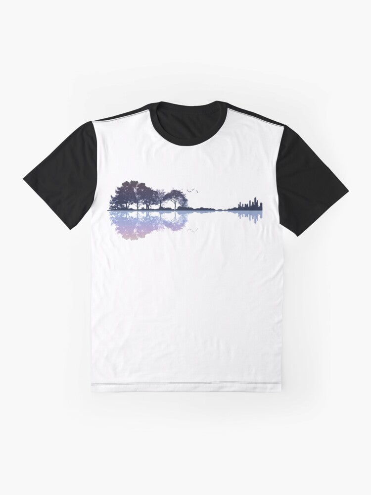 A nature-inspired graphic t-shirt featuring a guitar silhouette against a landscape with trees, water, and a cityscape. - Flat lay