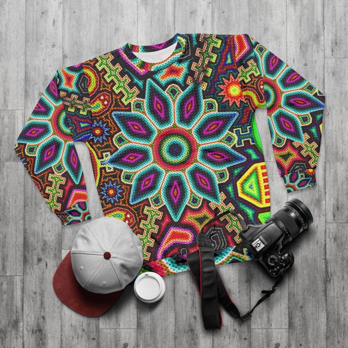 Huichol art inspired Mexican sweatshirt with vibrant colors and prehispanic design - flat lay