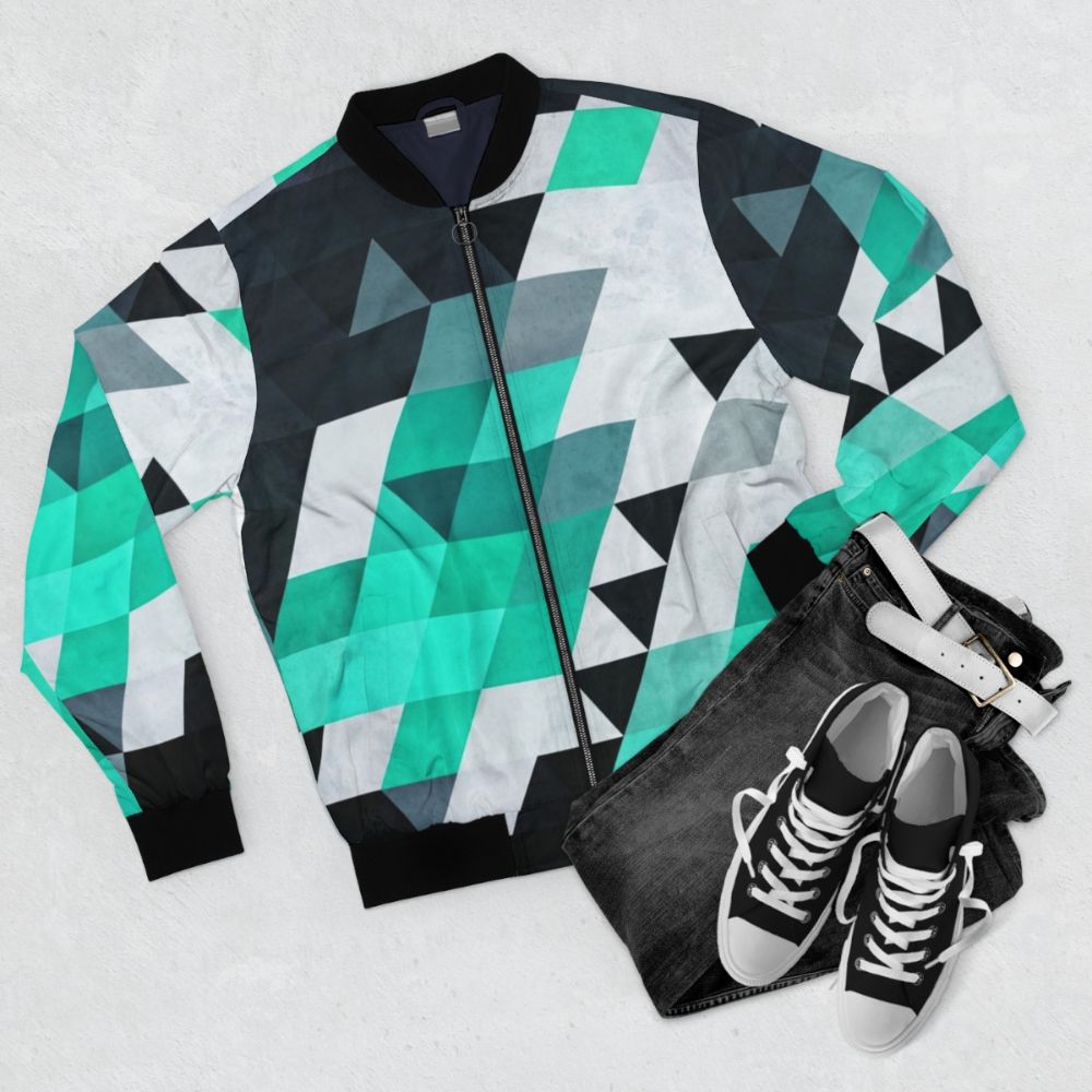 Modern geometric abstract pattern bomber jacket in teal, white, and black - Flat lay