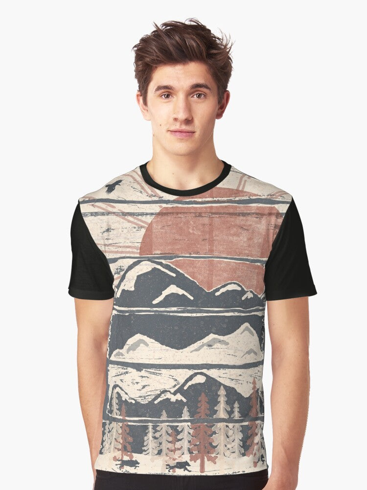 A graphic t-shirt featuring a winter landscape with wildlife such as wolves, hawks, and eagles. - Men