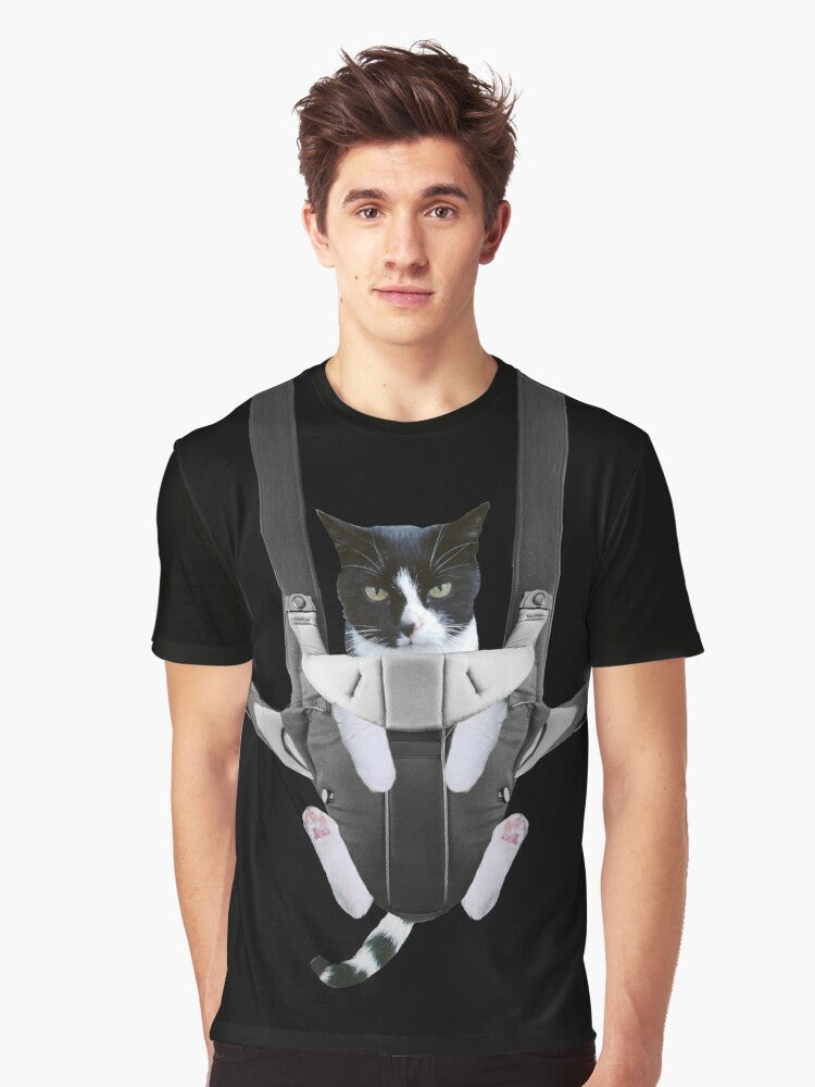 A graphic t-shirt design featuring a cute cat in a baby carrier - Men