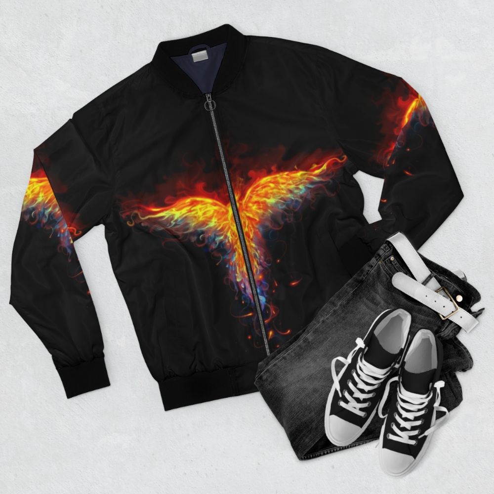 A bomber jacket with a phoenix design, featuring a mythical bird on fire against a backdrop of flames and fantasy elements. - Flat lay