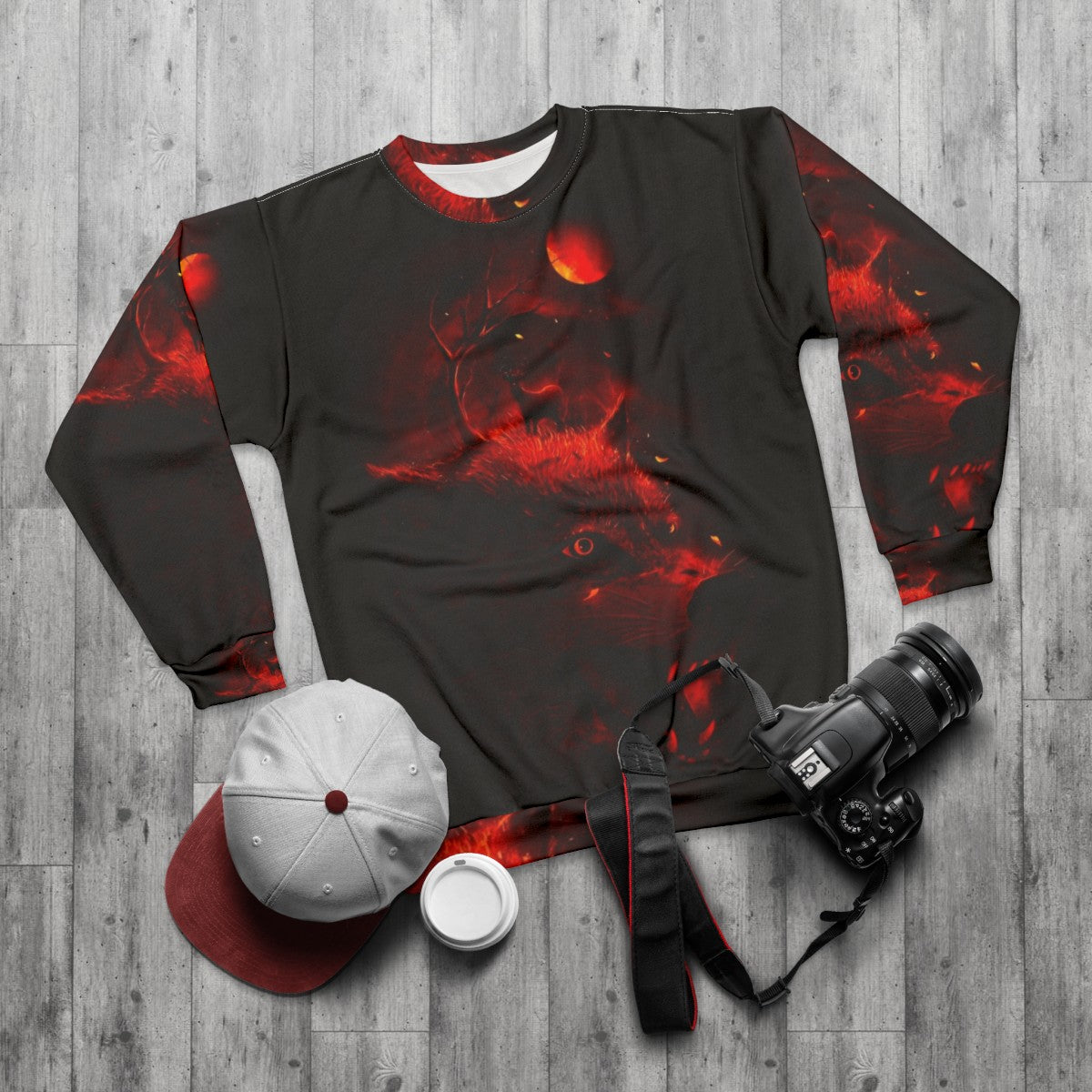 Red sweatshirt with dark night sky, wolf and deer silhouettes - flat lay