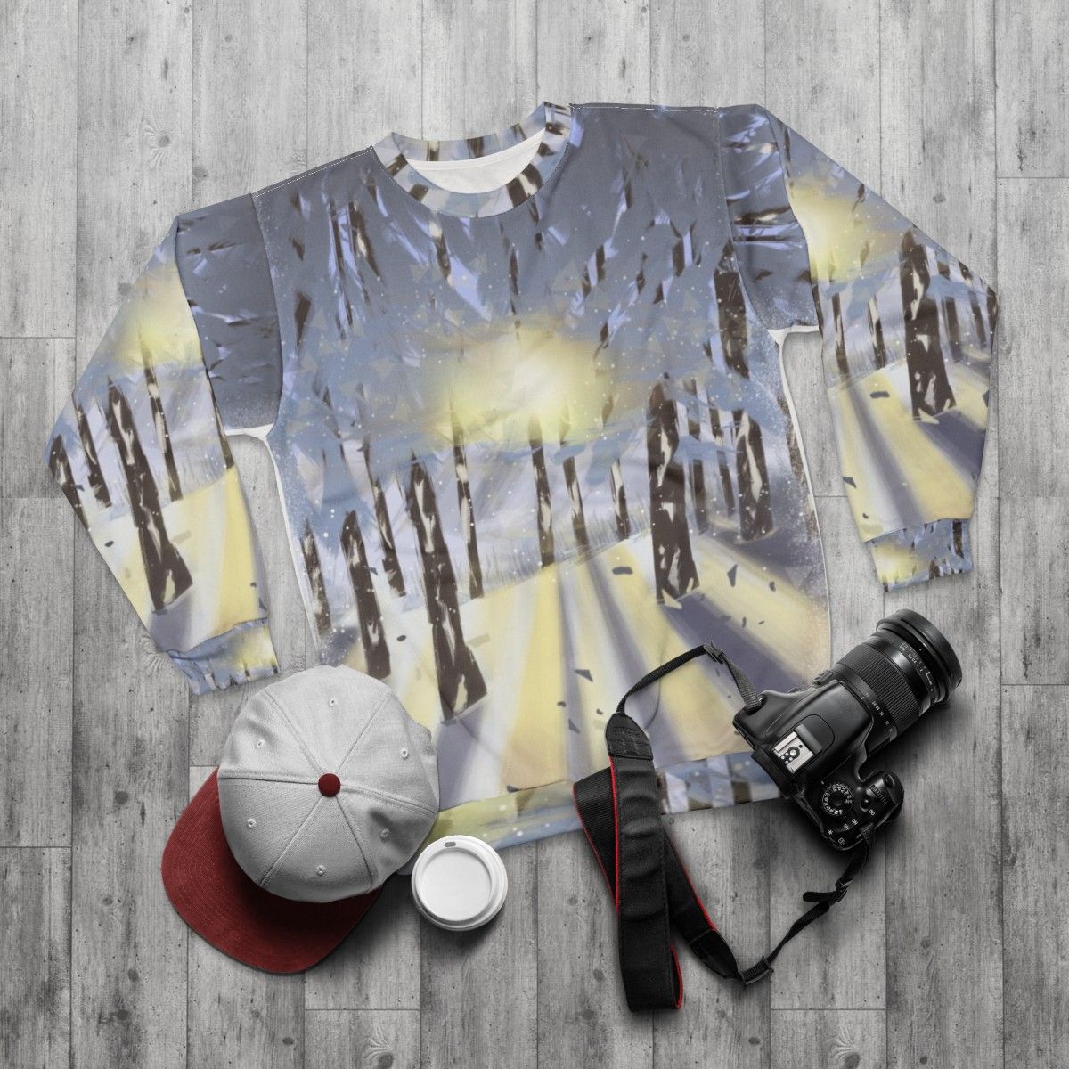 Cozy nature-inspired winter sweatshirt with forest and snow scene - flat lay