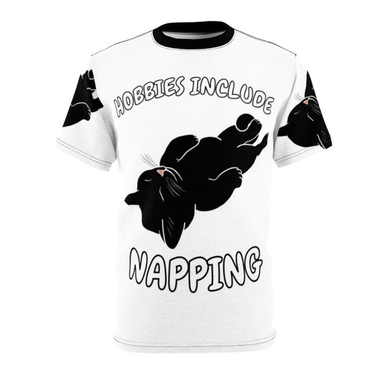 Image of a black cat curled up and napping on a t-shirt with the text "Hobbies Include Napping"