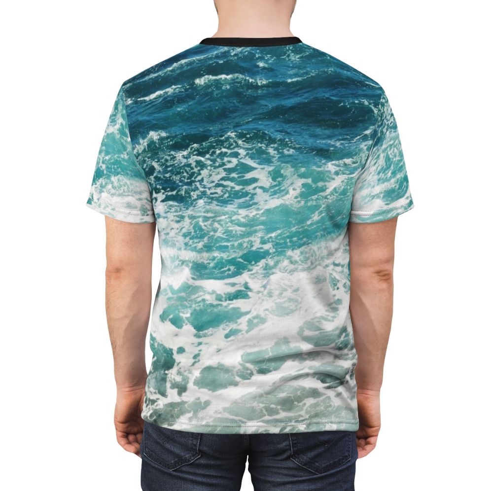 Model wearing a blue t-shirt with an abstract ocean waves pattern - men back