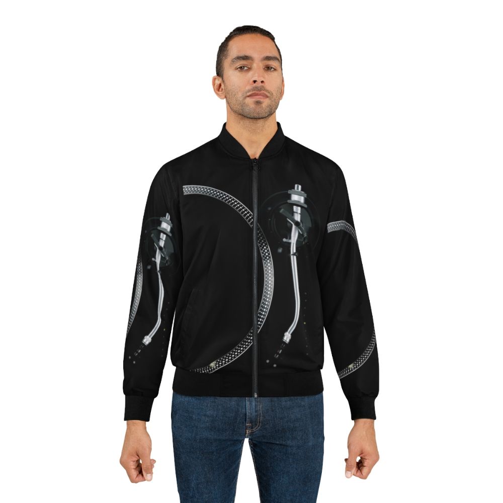 A sleek and stylish bomber jacket featuring a graphic design of a turntable, tone arm, and platter for music enthusiasts. - Lifestyle