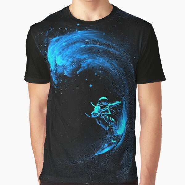 A graphic t-shirt design featuring an astronaut surfing through a colorful, cosmic galaxy filled with stars and swirling nebulas.