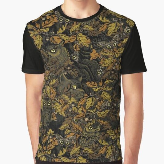 A graphic t-shirt featuring an owl design with autumn leaves, camouflage, and forest elements.