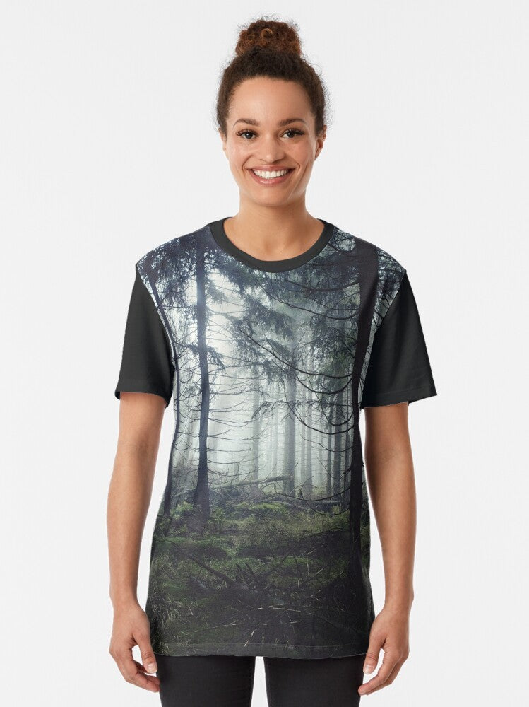 A vintage-inspired graphic t-shirt featuring a misty, foggy forest landscape with trees and mountains, perfect for nature and adventure lovers. - Women