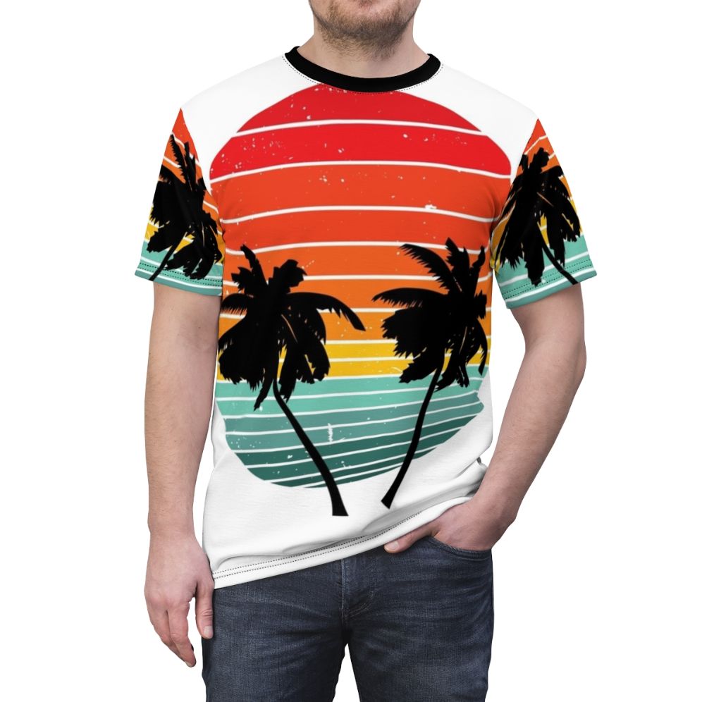 Person wearing a black t-shirt with a vivid tropical palm tree and sunrise silhouette design - men front