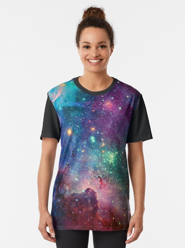 A colorful graphic t-shirt featuring a galaxy design with planets, stars, and cosmic elements. - Women