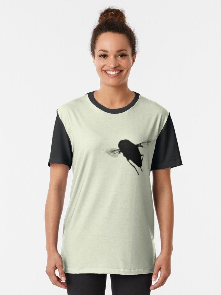 A minimalist silhouette design of a hover fly or syrphid fly on a black and cream t-shirt. - Women