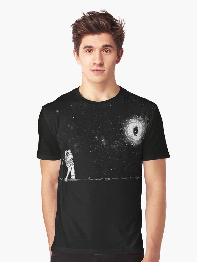 A graphic t-shirt featuring a black hole in one golf design, against a space and star-filled background. - Men