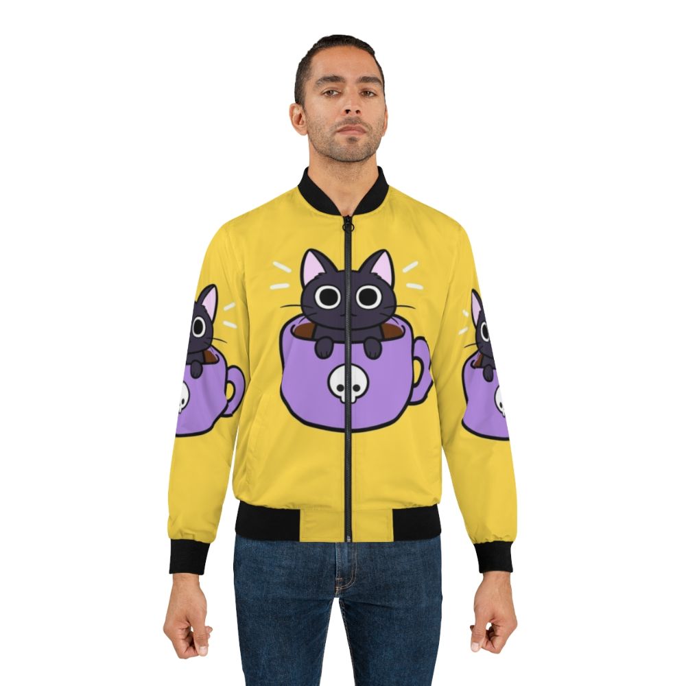 A black and purple bomber jacket with a cute, smiling cat print and coffee/drink elements. - Lifestyle