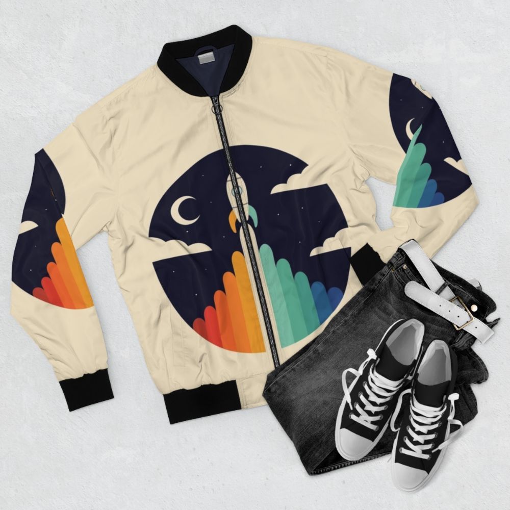 Up bomber jacket featuring a graphic of a rocket, moon, and clouds - Flat lay